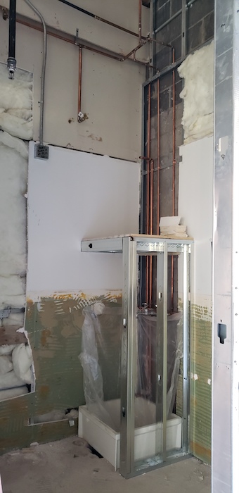 Showing metal stud water heater stand surrounding mop sink.